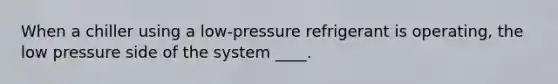 When a chiller using a low-pressure refrigerant is operating, the low pressure side of the system ____.