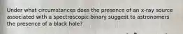 Under what circumstances does the presence of an x-ray source associated with a spectroscopic binary suggest to astronomers the presence of a black hole?