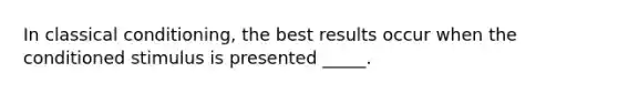 In classical conditioning, the best results occur when the conditioned stimulus is presented _____.