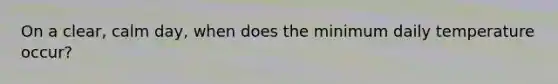 On a clear, calm day, when does the minimum daily temperature occur?