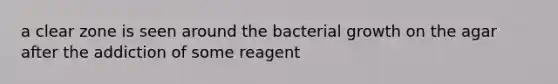 a clear zone is seen around the bacterial growth on the agar after the addiction of some reagent