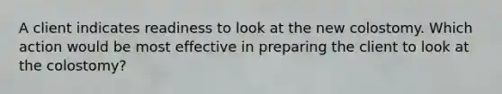 A client indicates readiness to look at the new colostomy. Which action would be most effective in preparing the client to look at the colostomy?