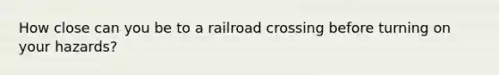 How close can you be to a railroad crossing before turning on your hazards?