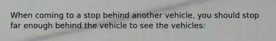 When coming to a stop behind another vehicle, you should stop far enough behind the vehicle to see the vehicles: