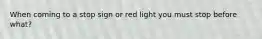 When coming to a stop sign or red light you must stop before what?