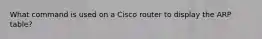 What command is used on a Cisco router to display the ARP table?