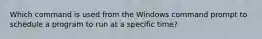 Which command is used from the Windows command prompt to schedule a program to run at a specific time?