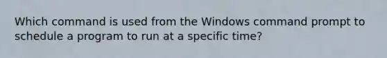 Which command is used from the Windows command prompt to schedule a program to run at a specific time?