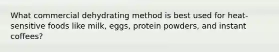 What commercial dehydrating method is best used for heat-sensitive foods like milk, eggs, protein powders, and instant coffees?