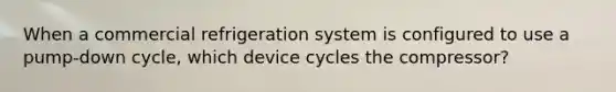 When a commercial refrigeration system is configured to use a pump-down cycle, which device cycles the compressor?