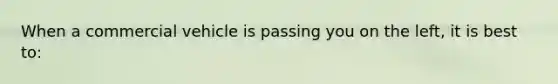 When a commercial vehicle is passing you on the left, it is best to: