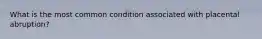 What is the most common condition associated with placental abruption?