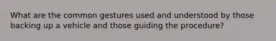 What are the common gestures used and understood by those backing up a vehicle and those guiding the procedure?