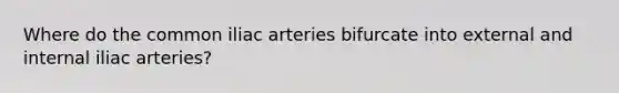 Where do the common iliac arteries bifurcate into external and internal iliac arteries?