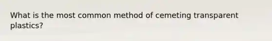 What is the most common method of cemeting transparent plastics?