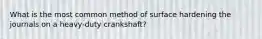 What is the most common method of surface hardening the journals on a heavy-duty crankshaft?