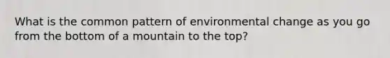 What is the common pattern of environmental change as you go from the bottom of a mountain to the top?