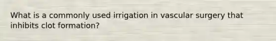 What is a commonly used irrigation in vascular surgery that inhibits clot formation?