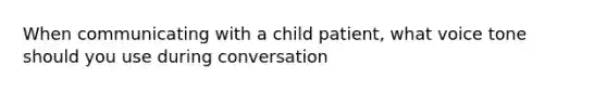 When communicating with a child patient, what voice tone should you use during conversation