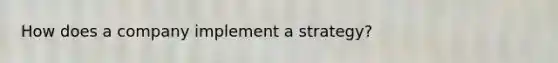 How does a company implement a strategy?