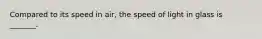 Compared to its speed in air, the speed of light in glass is _______.