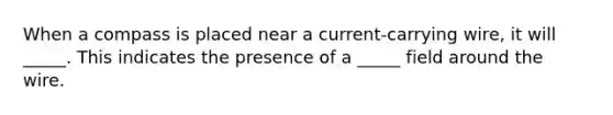 When a compass is placed near a current-carrying wire, it will _____. This indicates the presence of a _____ field around the wire.