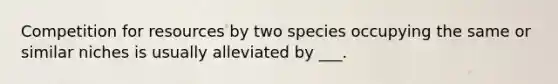 Competition for resources by two species occupying the same or similar niches is usually alleviated by ___.