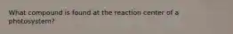 What compound is found at the reaction center of a photosystem?