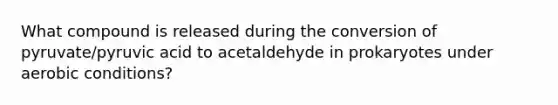 What compound is released during the conversion of pyruvate/pyruvic acid to acetaldehyde in prokaryotes under aerobic conditions?