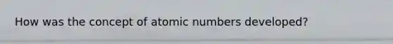 How was the concept of atomic numbers developed?