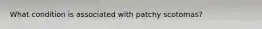 What condition is associated with patchy scotomas?