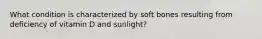 What condition is characterized by soft bones resulting from deficiency of vitamin D and sunlight?