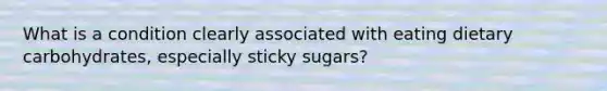 What is a condition clearly associated with eating dietary carbohydrates, especially sticky sugars?