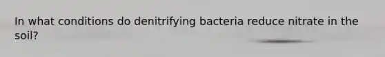 In what conditions do denitrifying bacteria reduce nitrate in the soil?