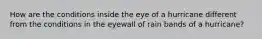 How are the conditions inside the eye of a hurricane different from the conditions in the eyewall of rain bands of a hurricane?