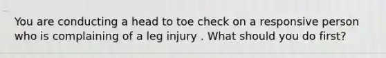 You are conducting a head to toe check on a responsive person who is complaining of a leg injury . What should you do first?