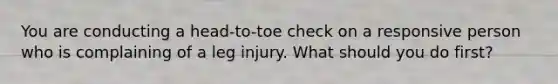 You are conducting a head-to-toe check on a responsive person who is complaining of a leg injury. What should you do first?