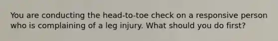 You are conducting the head-to-toe check on a responsive person who is complaining of a leg injury. What should you do first?