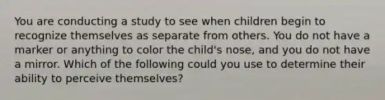 You are conducting a study to see when children begin to recognize themselves as separate from others. You do not have a marker or anything to color the child's nose, and you do not have a mirror. Which of the following could you use to determine their ability to perceive themselves?