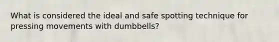 What is considered the ideal and safe spotting technique for pressing movements with dumbbells?