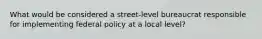 What would be considered a street-level bureaucrat responsible for implementing federal policy at a local level?