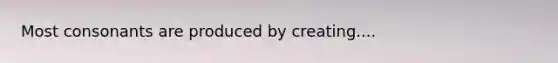 Most consonants are produced by creating....