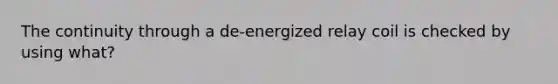 The continuity through a de-energized relay coil is checked by using what?