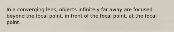 In a converging lens, objects infinitely far away are focused beyond the focal point. in front of the focal point. at the focal point.