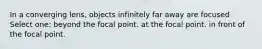 In a converging lens, objects infinitely far away are focused Select one: beyond the focal point. at the focal point. in front of the focal point.