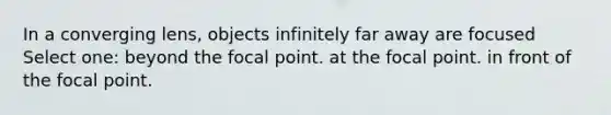 In a converging lens, objects infinitely far away are focused Select one: beyond the focal point. at the focal point. in front of the focal point.