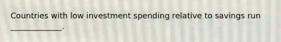 Countries with low investment spending relative to savings run _____________.