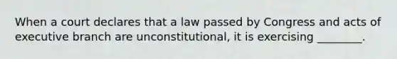 ​When a court declares that a law passed by Congress and acts of executive branch are unconstitutional, it is exercising ________.