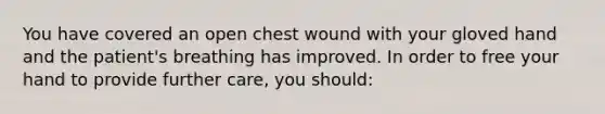 You have covered an open chest wound with your gloved hand and the​ patient's breathing has improved. In order to free your hand to provide further​ care, you​ should: