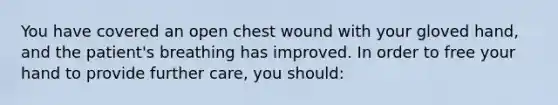 You have covered an open chest wound with your gloved hand, and the patient's breathing has improved. In order to free your hand to provide further care, you should: